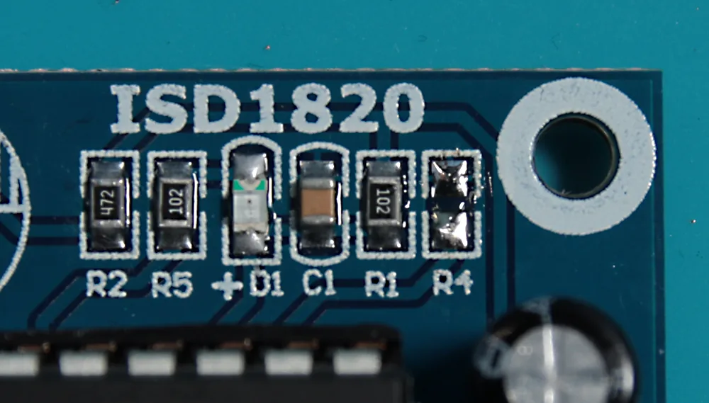 Close-up of the board's top-right corner with the R4 surface-mount resistor removed, leaving two empty pads.