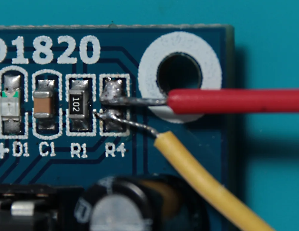 Two wires soldered onto the R4 SMD pads, sitting close together; the cables were later glued to the board for extra security.