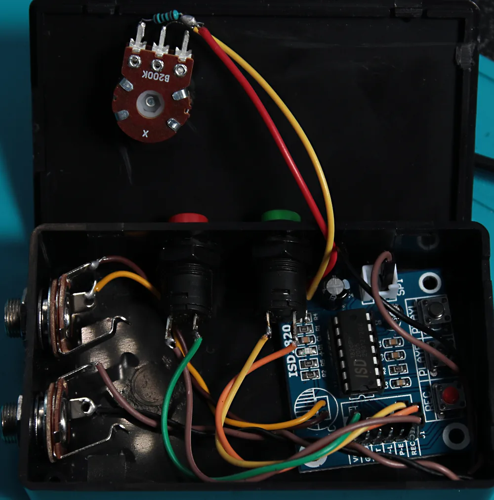The finished sampler crammed into a tiny box, power not yet connected and the speaker cable disconnected, showing how all the cables route to the header pins.
