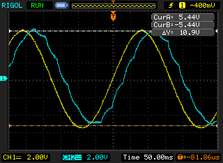 Oscilloscope capture with glide high: the cyan output has stopped looking stepped at all and is now a smooth wavy curve that lags behind the yellow sine wave, rounded and shifted later in time. Both channels at 2V per division, 50 milliseconds per division.