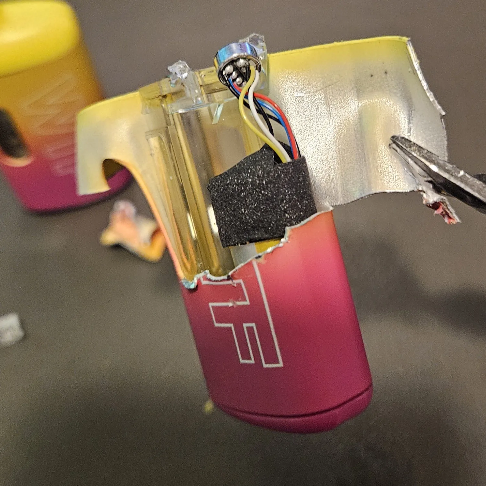 The bare lithium cell freed from its wrap, its little protection board and a scrap of black foam still attached.