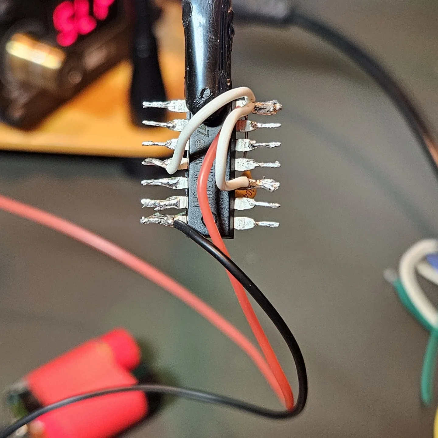 The chip fully powered: red V-plus wire, black ground wire, and white reset jumpers all soldered, with the '104' decoupling cap in place.