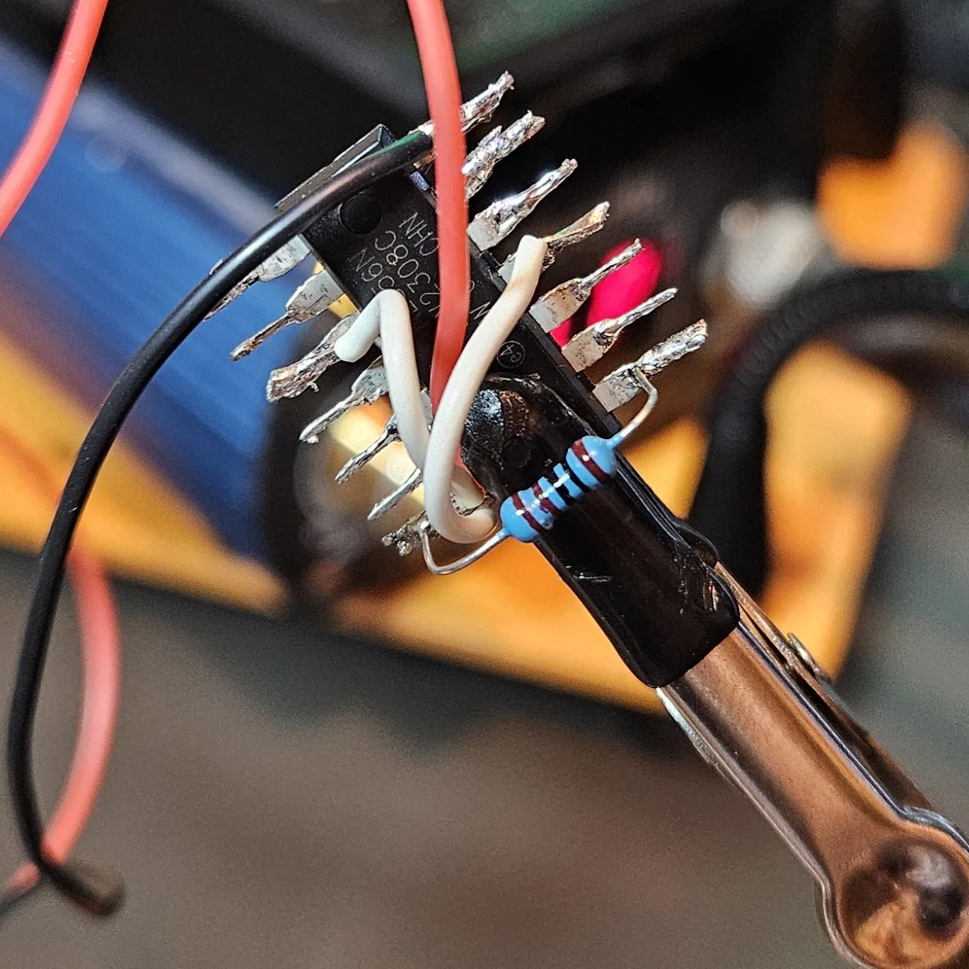 The 1K series resistor soldered onto the chip near the discharge pin, one lead bridging over to the V-plus side.