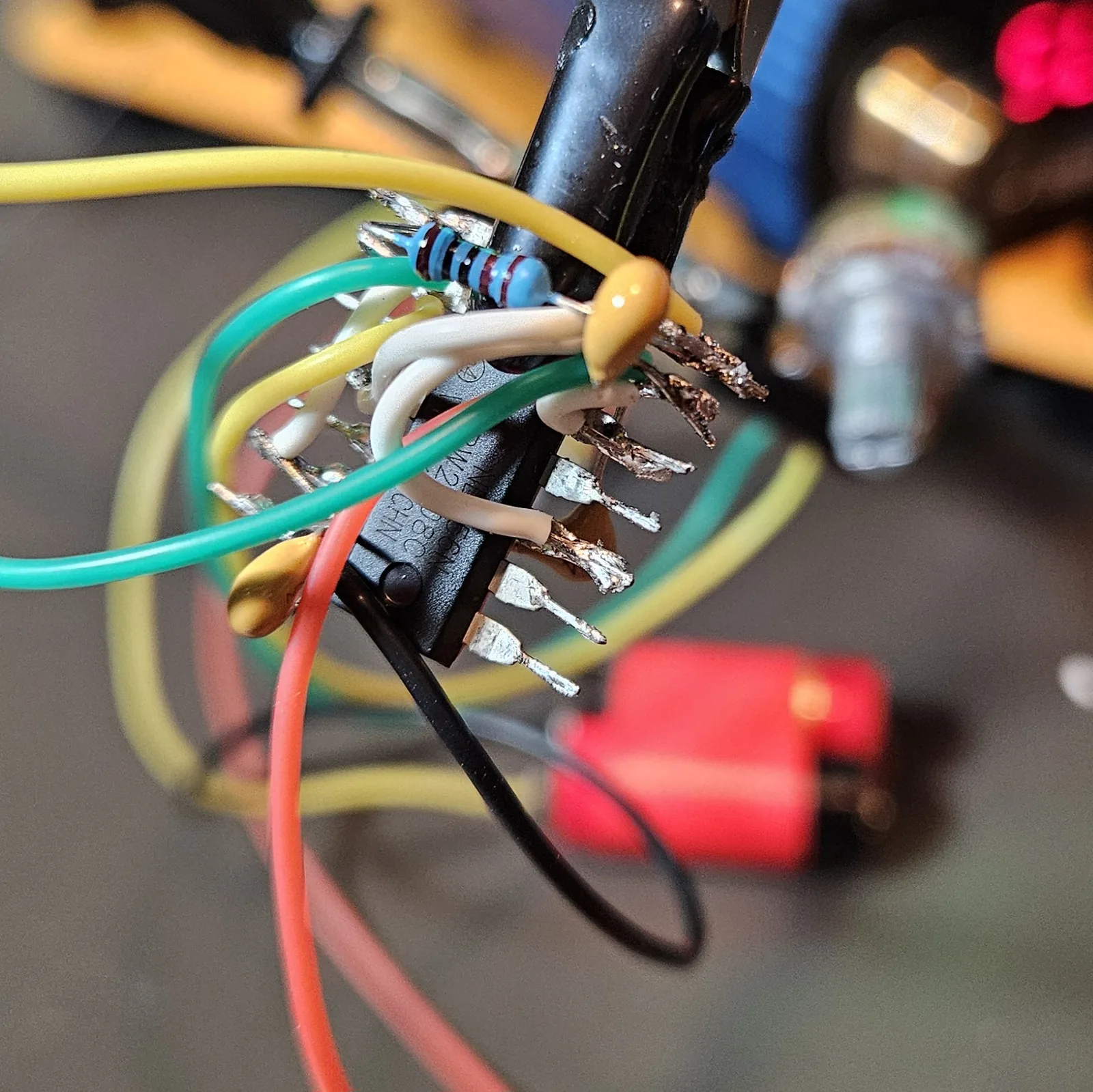 Another angle of the growing wiring nest on the dead-bug NE556, with the second B500K potentiometer visible in the soft-focus background.