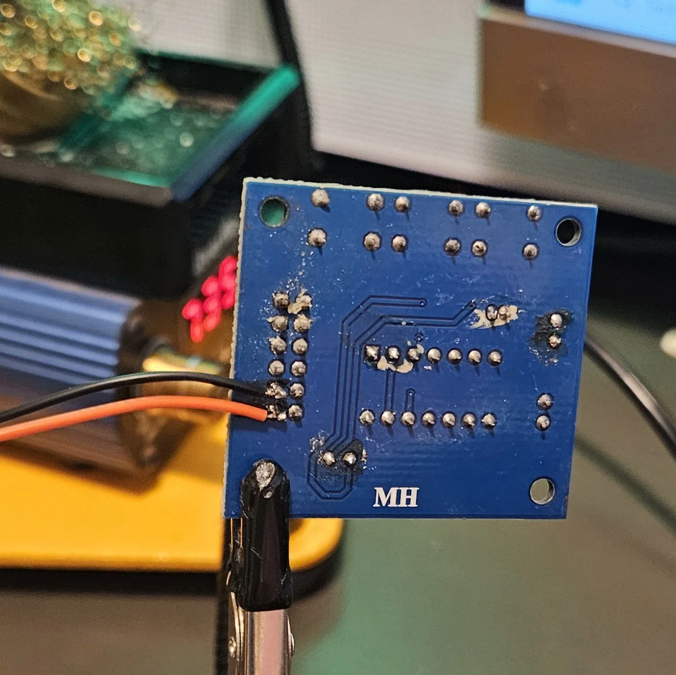 The back of the module with the orange and black power leads now soldered onto the pads at the left-hand edge of the header.