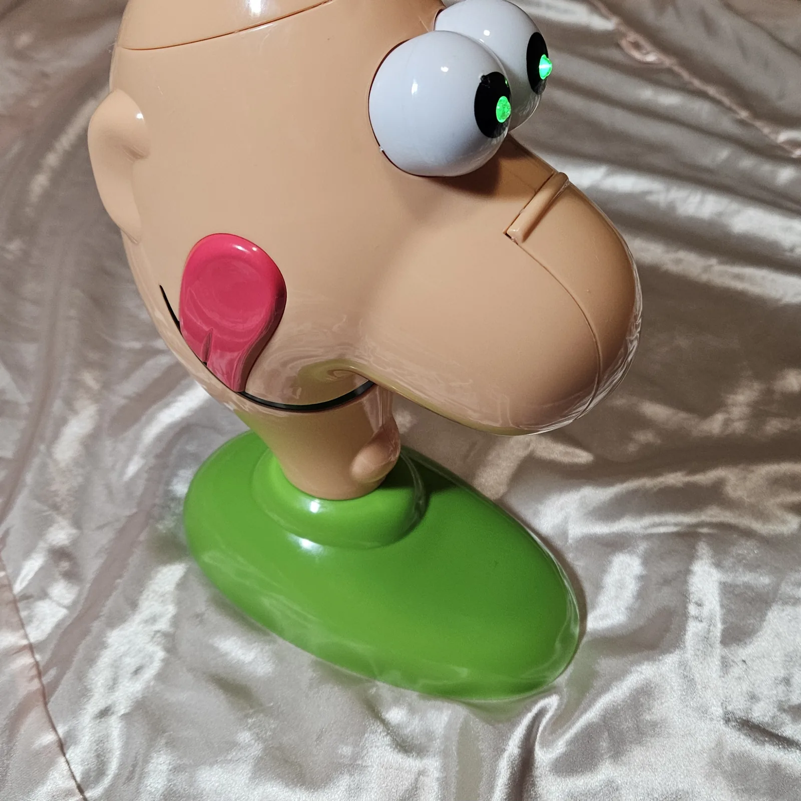 Loopy Louie - a repurposed Gooey Louie game head with a big nose on a green base, its white googly eyes glowing green from installed LEDs, housing a lo-fi ISD1820 looper