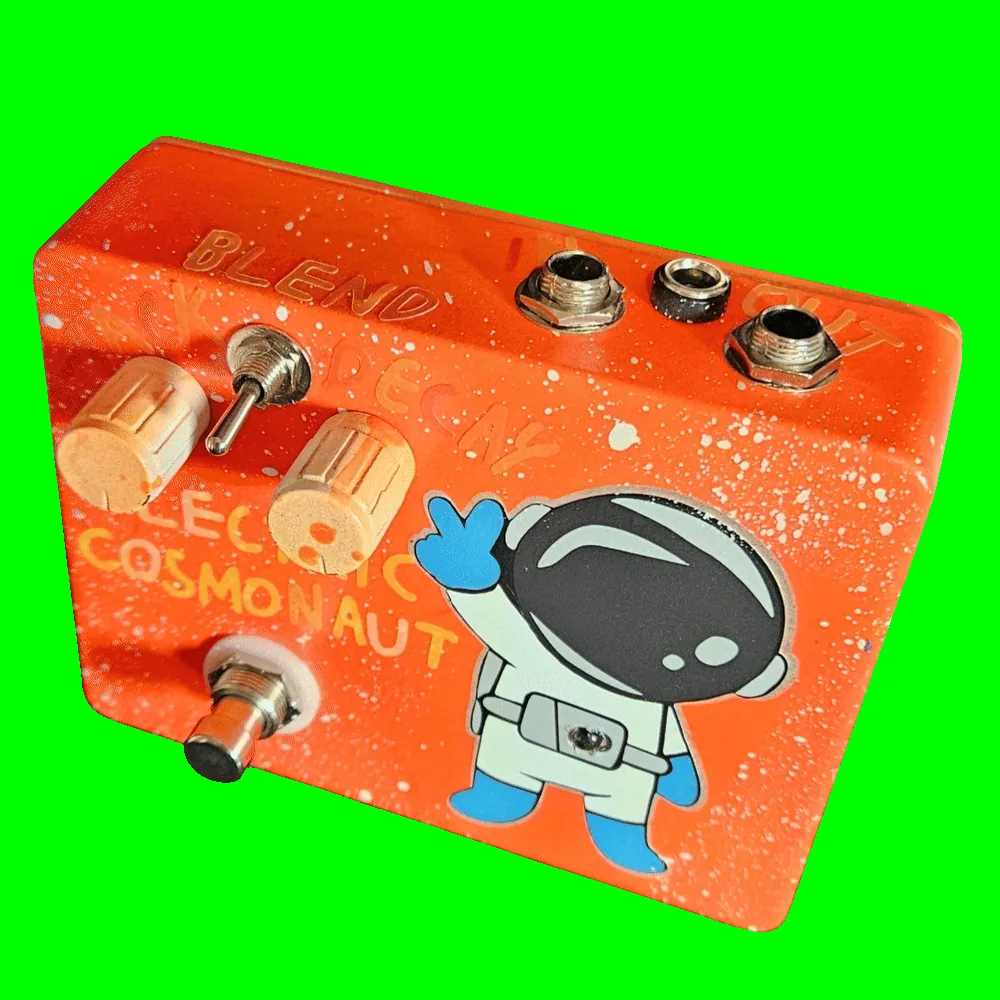 Top-down view of the wide enclosure: the top edge carries a 1/4-inch jack near each end with a DC power jack between them, and "OUT" engraved beside the right-hand jack. "BLEND" is engraved above the small toggle switch with "DECAY" to its right, above the two ribbed cream knobs.