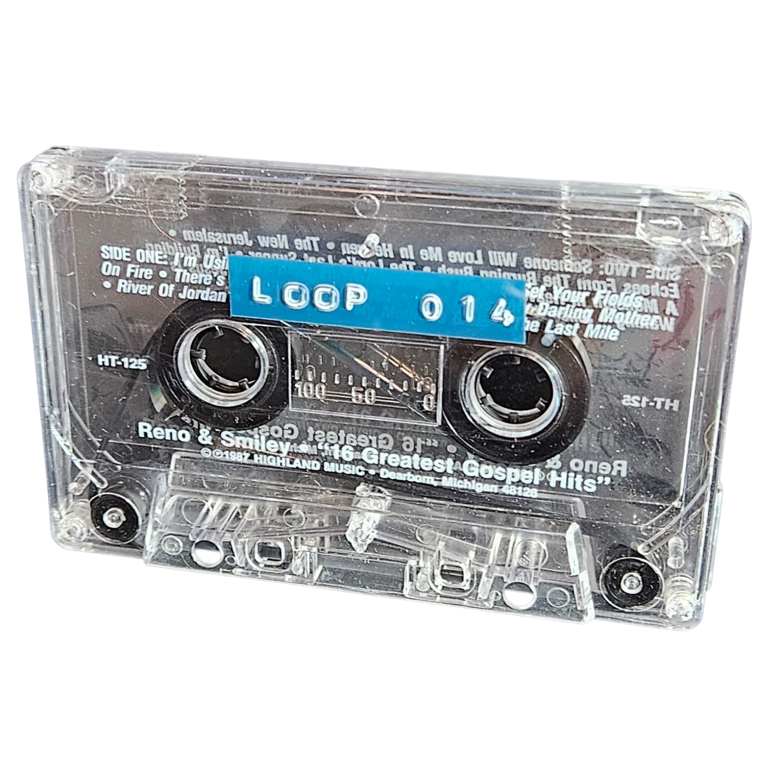 Clear cassette shell labeled Loop 014 on a blue strip, recycled from a 1987 Reno and Smiley gospel cassette with the original track titles still printed underneath