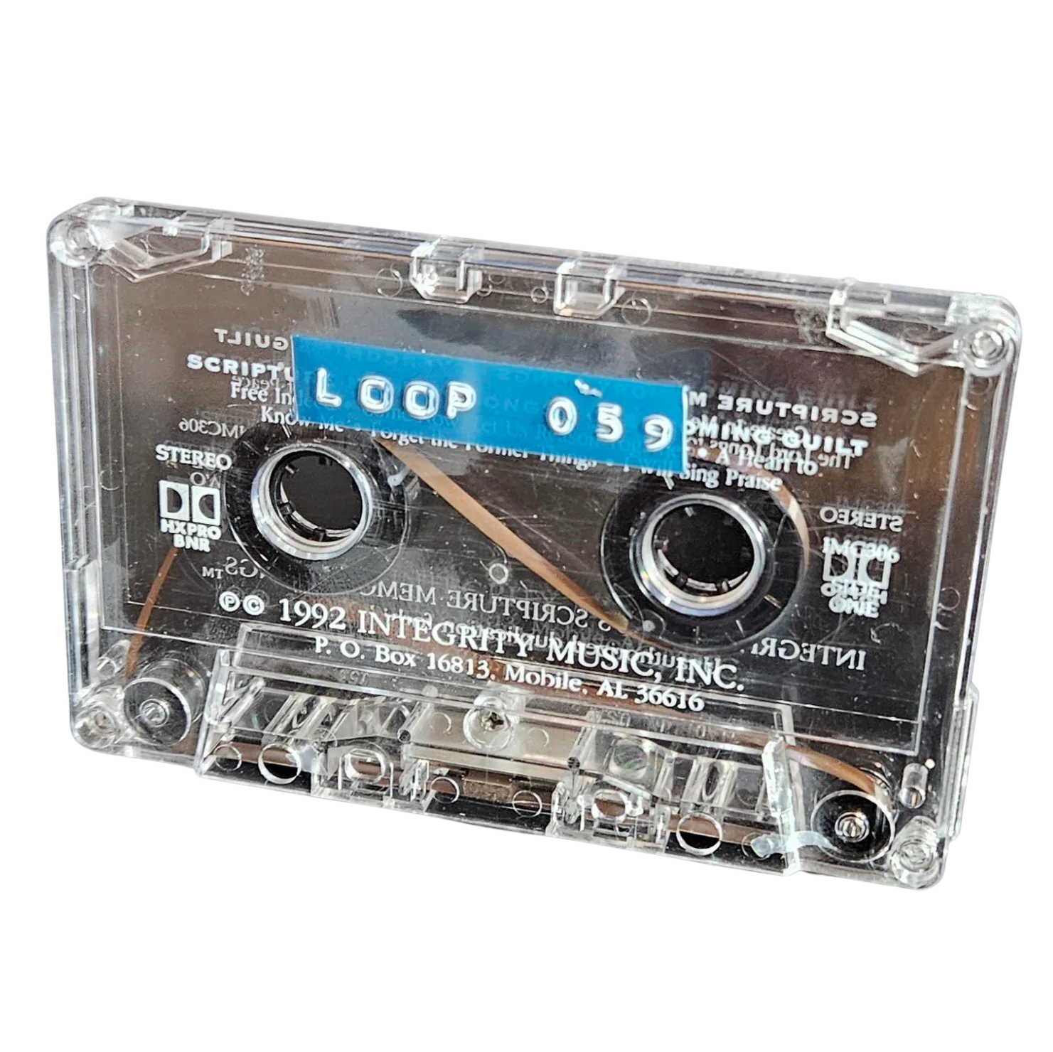 Clear cassette shell labeled Loop 059 on a blue strip, recycled from a 1992 Integrity Music scripture cassette